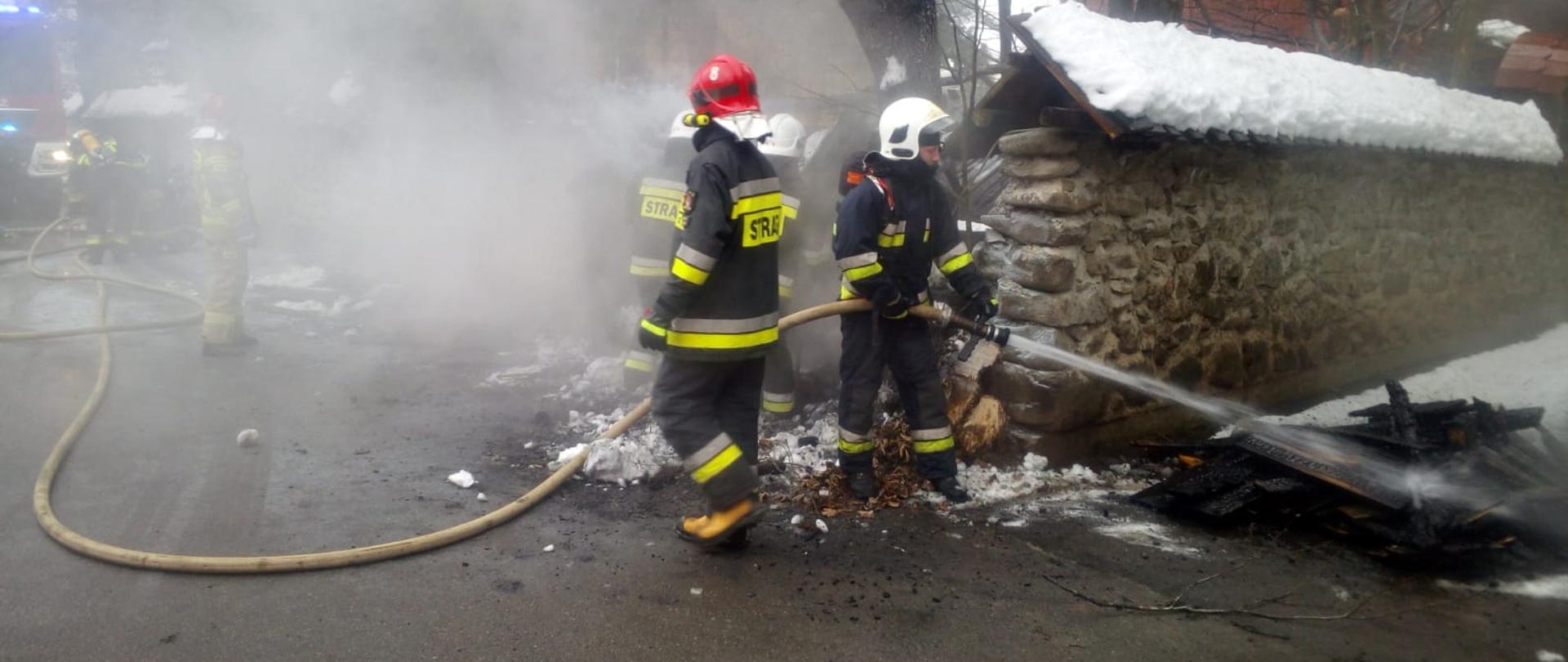 Zdjęcie przedstawia strażaków gaszących pożar