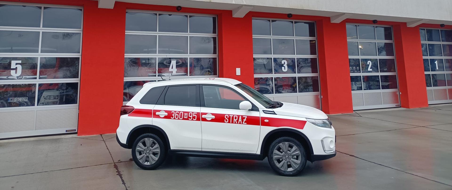 Na zdjęciu nowy samochód operacyjny SUZUKI na tle bram garażowych JRG 1.