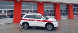 Na zdjęciu nowy samochód operacyjny SUZUKI na tle bram garażowych JRG 1.