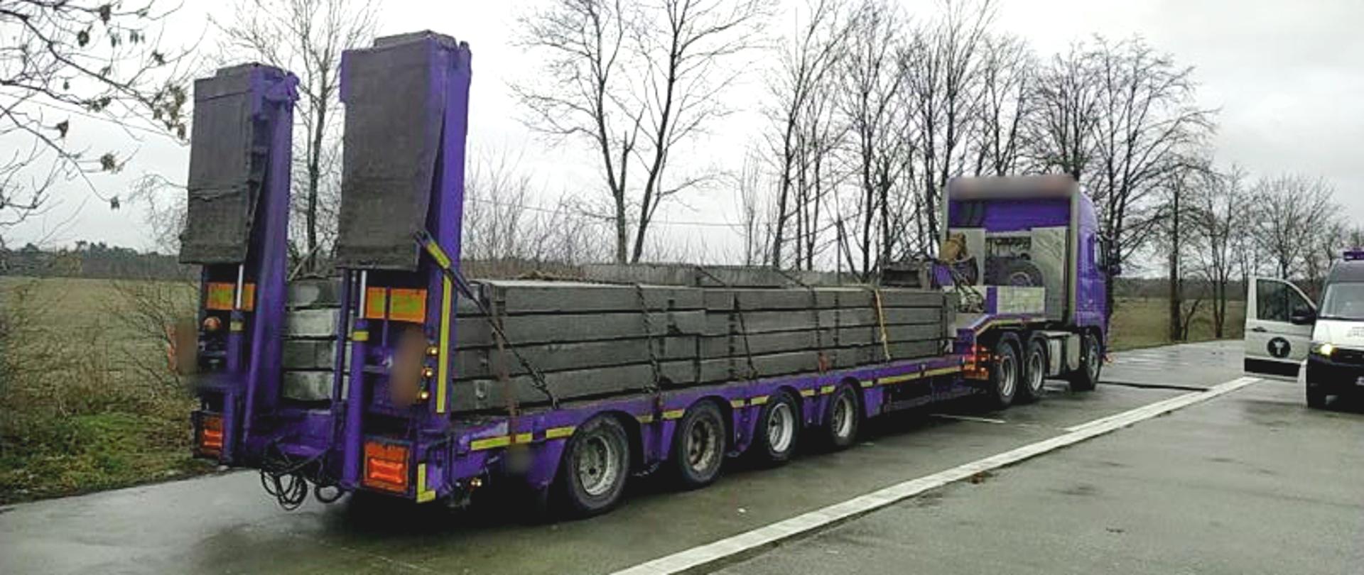 Kontrola zespołu pojazdów zatrzymanego przez inspektorów kujawsko-pomorskiej ITD. Po lewej ciągnik siodłowy z naczepą, po prawej furgon Inspekcji Transportu Drogowego. Na naczepie betonowe płyty.