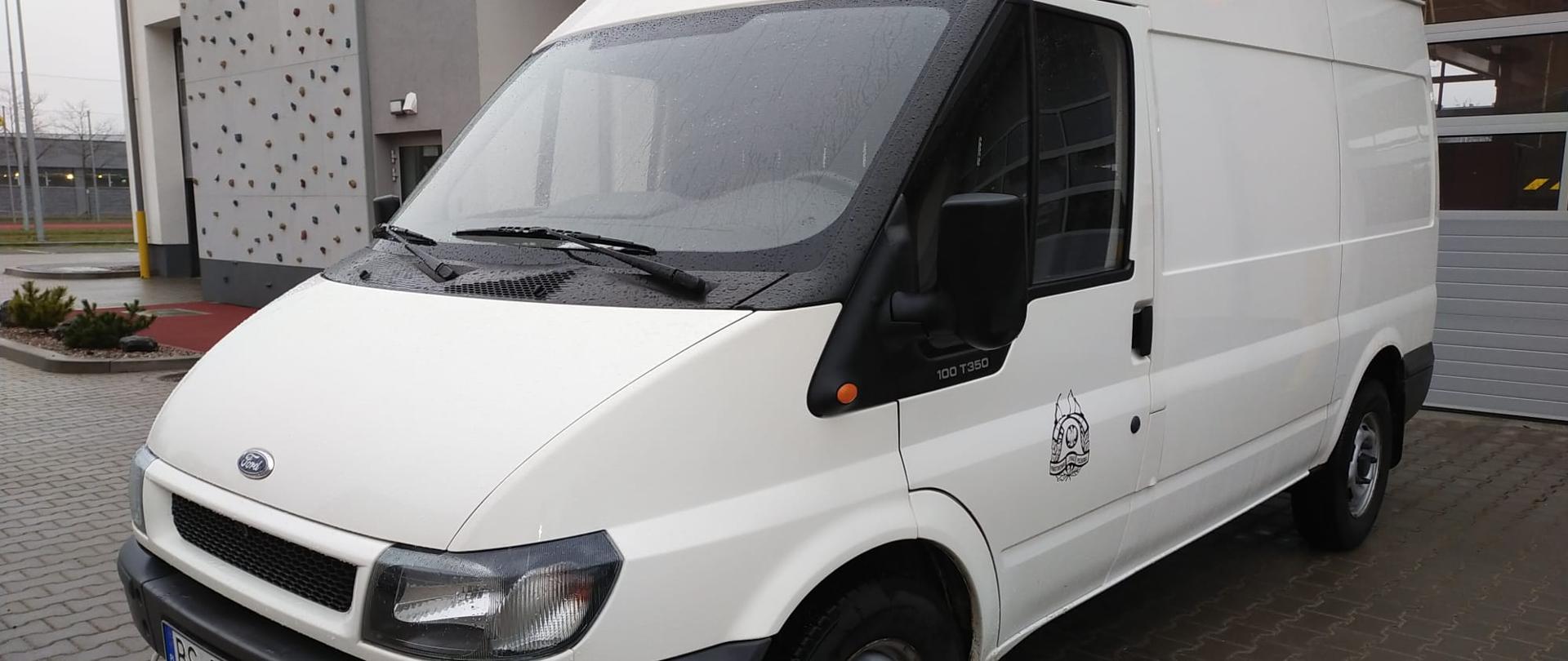 Biały samochód na tle bram garażowych