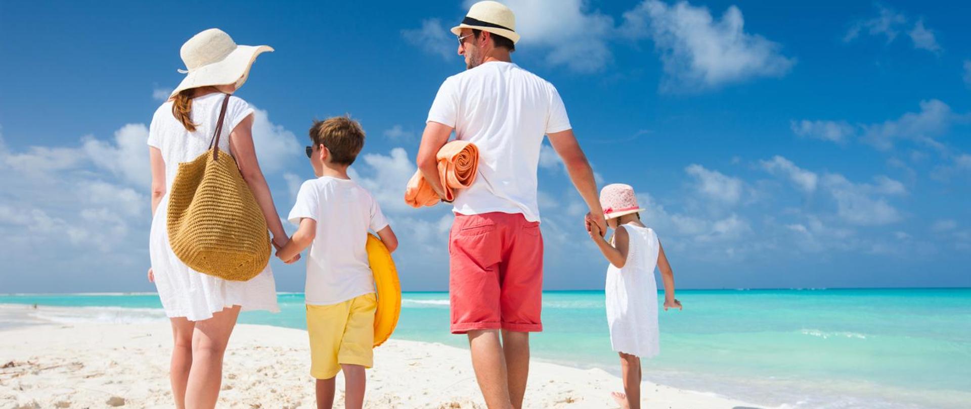 Czteroosobowa rodzina na plaży dwoje dorosłych i dwójka dzieci w plażowych strojach