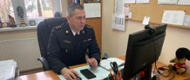Na zdjęciu widać dowódcę JRG w Chełmnie. Siedzi przy biurku rozmawia z kimś przez wideokonferencję