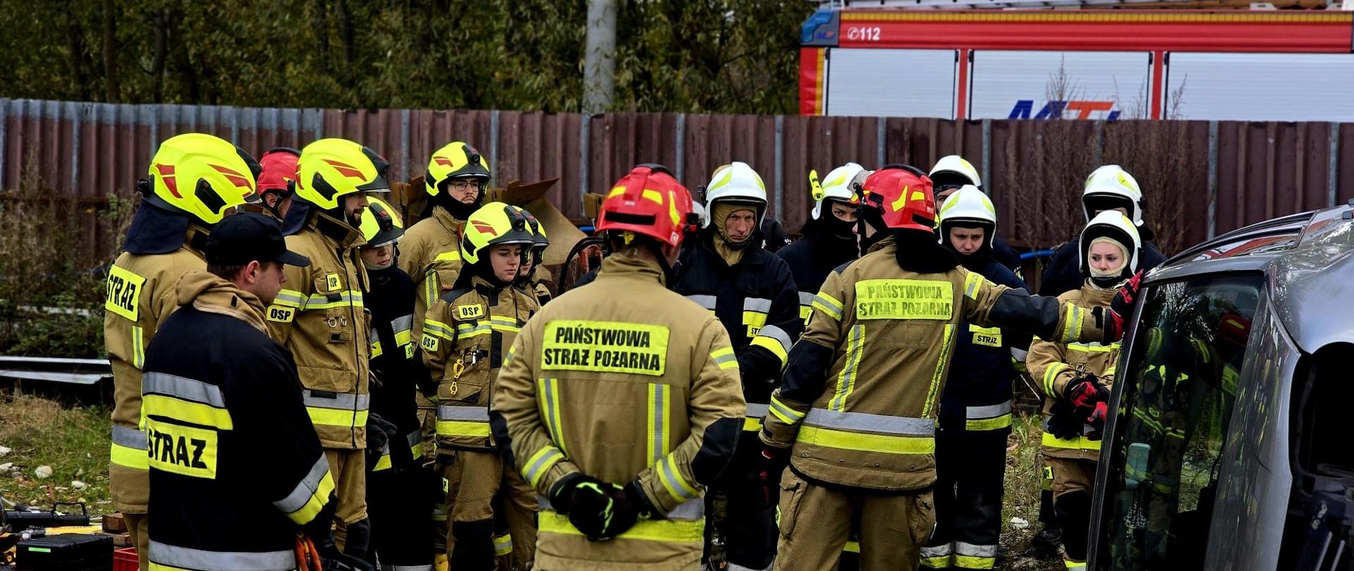 Zdjęcie przedstawia uczestników kursu słuchających instruktora podczas omawiania założenia