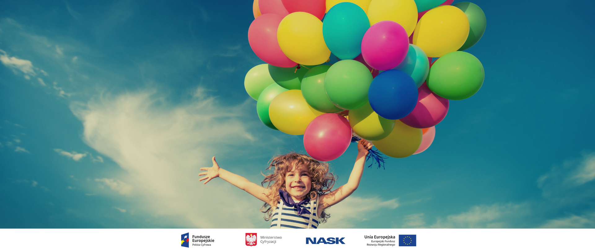 Uśmiechnięta dziewczynka trzymająca kolorowe baloniki