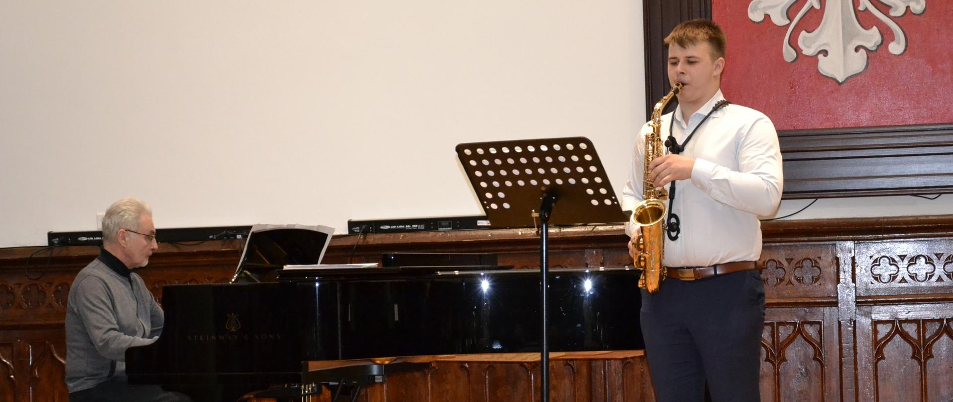 Dawid Machnik oraz akompaniator Jan Lubieniecki podczas recitalu muzyki saksofonowej na scenie w Sali Królewskiej PSM w Mielcu