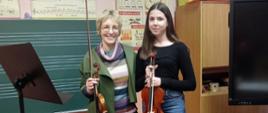 Prowadząca warsztaty i uczennica trzymające skrzypce
