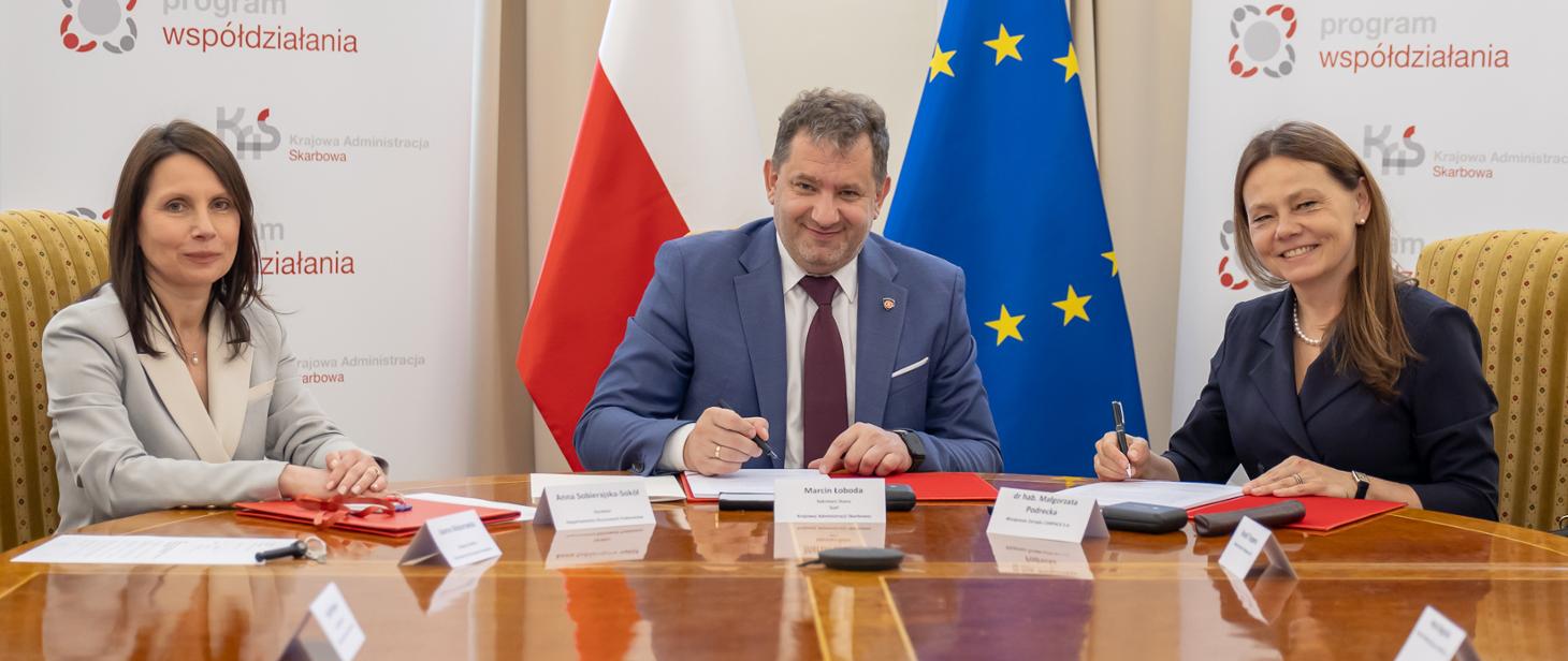 Podpisywanie umowy w ramach Programu Współdziałania, na środku Szef Krajowej Administracji Skarbowej Marcin Łoboda.