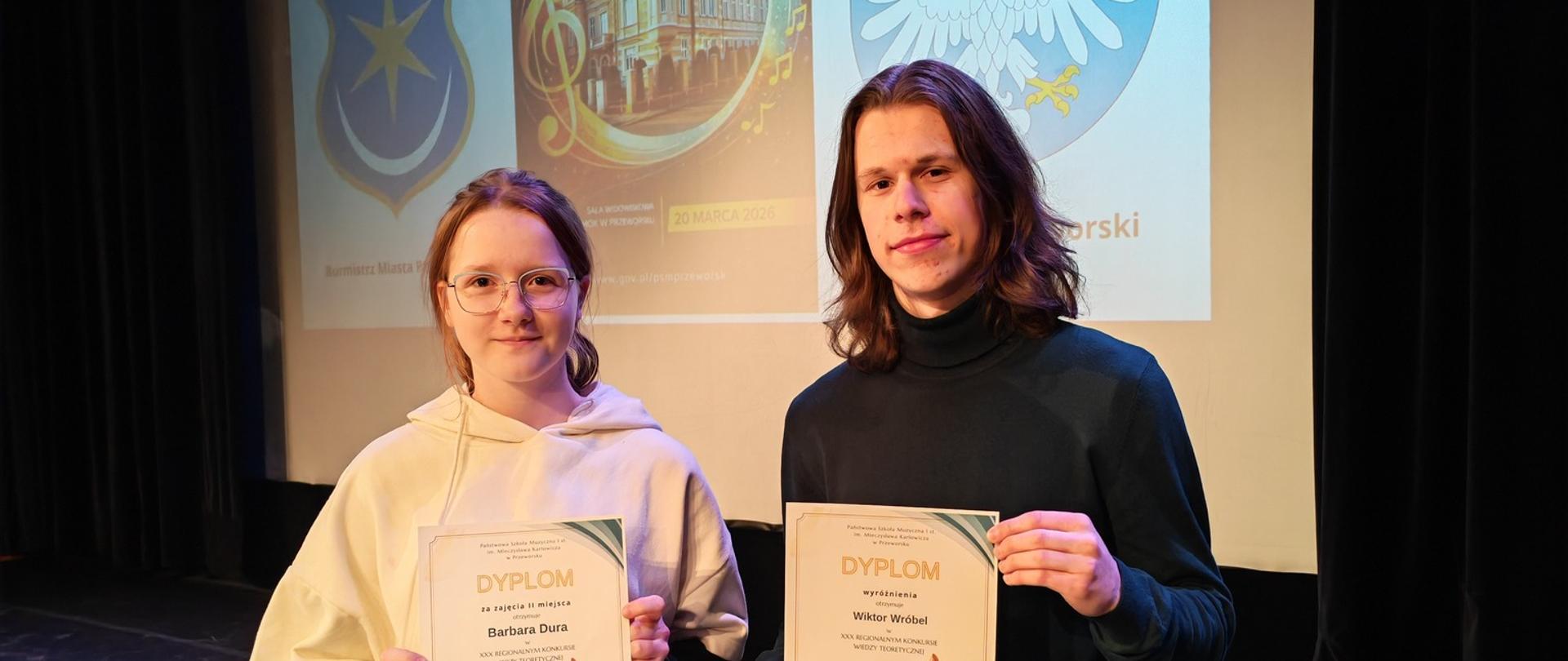 Dwoje uczniów prezentujących dyplomy na scenie podczas XXX Regionalnego Konkursu Wiedzy Teoretycznej w Przeworsku, w którym zdobyli II miejsce i wyróżnienie.