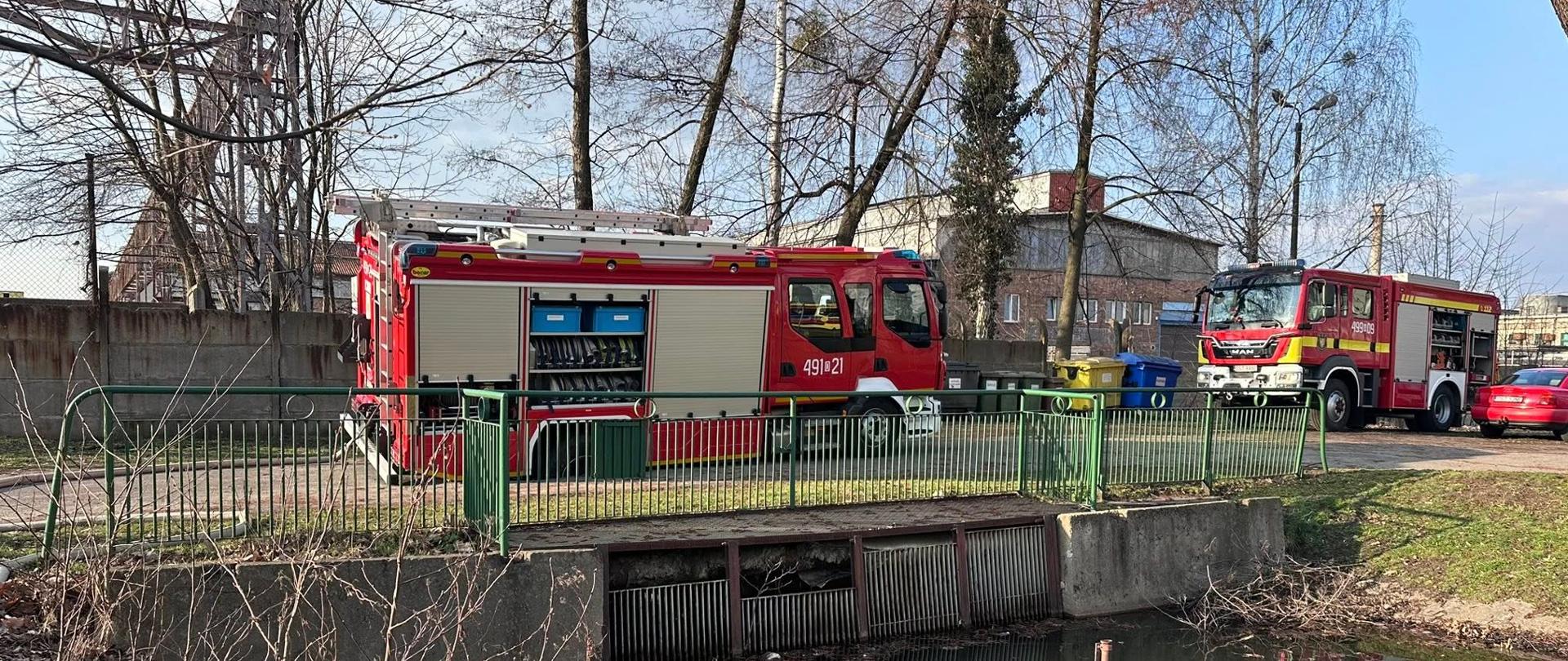 Na zdjęciu znajduje się samochód strażacki z kołem zapadniętym w drodze, w tle widać inne samochody oraz balustradę mostu