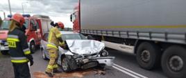 Działania ratownicze strażaków przy rozbitym aucie BMW