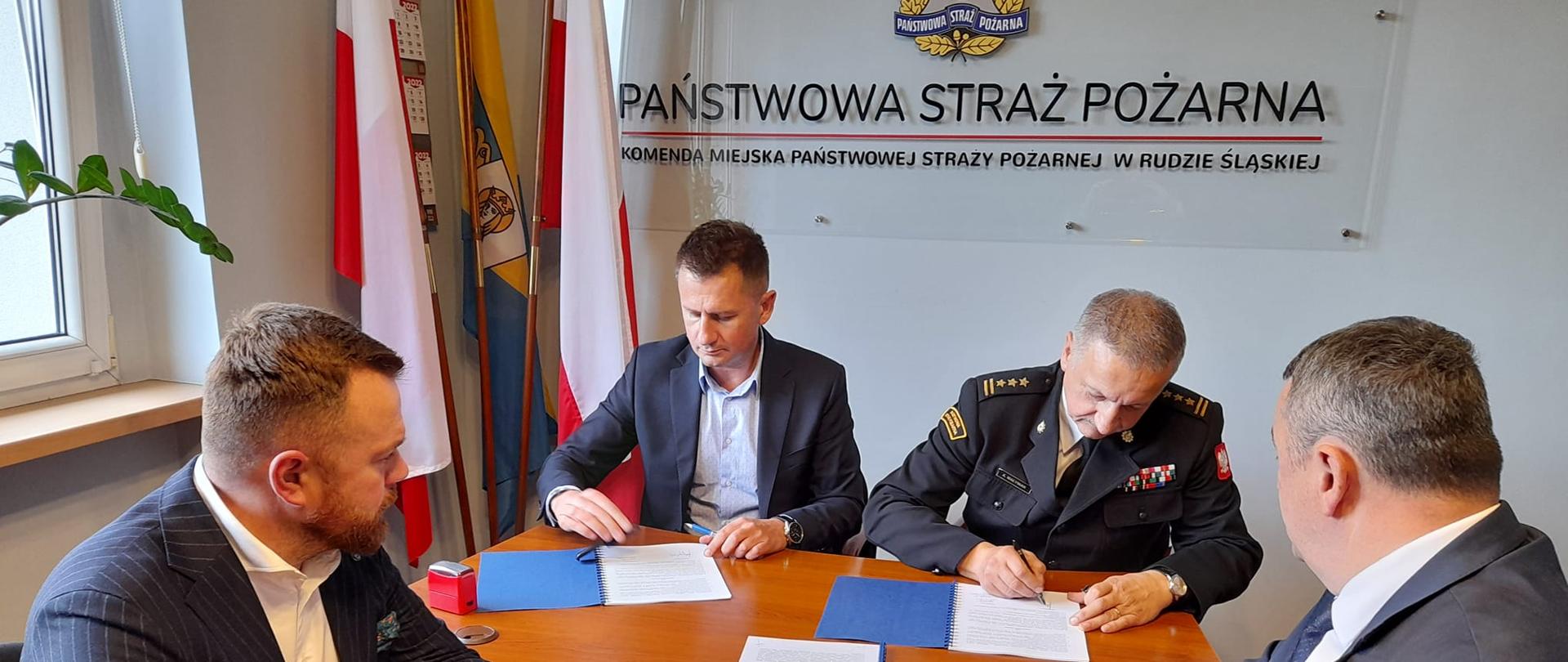 Zdjęcie przedstawia spotkanie, na którym Komendant PSP w Rudzie Śląskiej podpisuje umowę z firmą ANNA-BUD sp. z o.o. na budowę nowej strażnicy PSP w Rudzie Śląskiej.