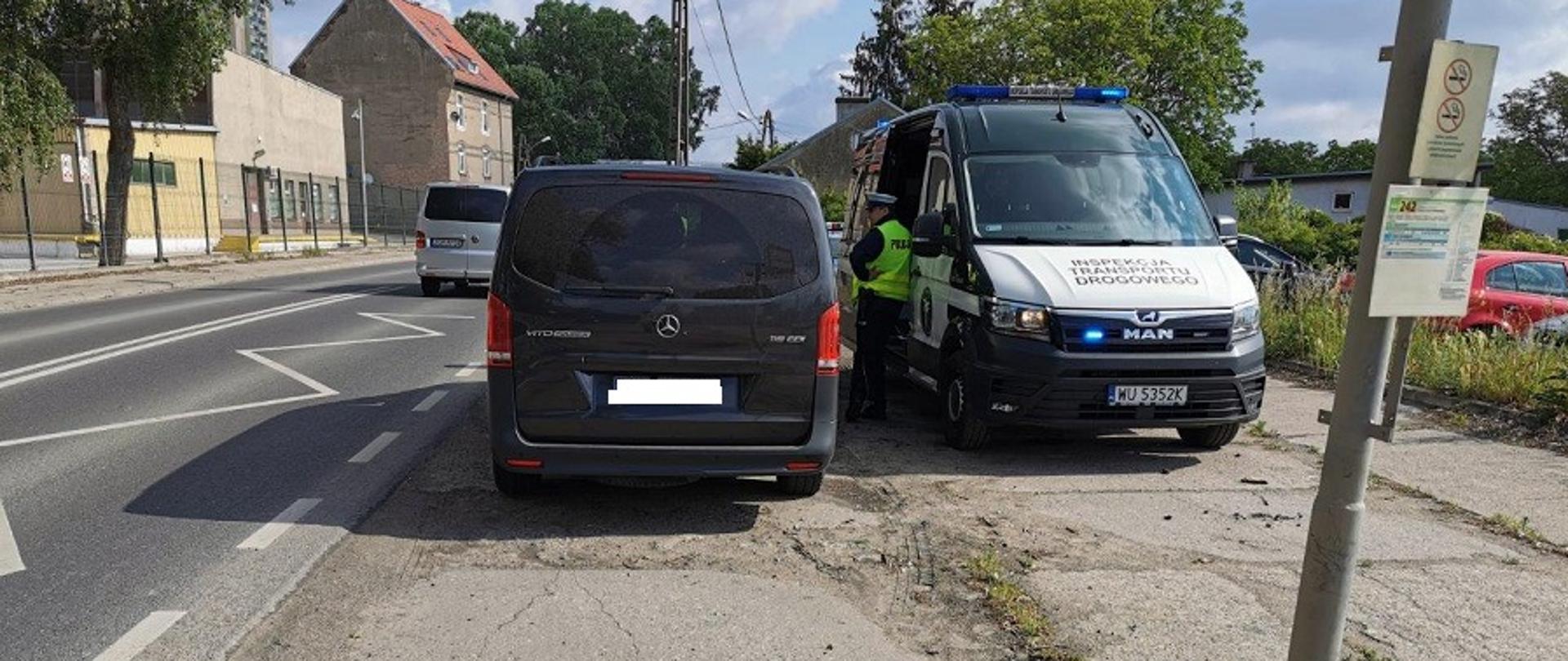 Na zdjęciu widzimy radiowóz oraz zatrzymany bus do kontroli 