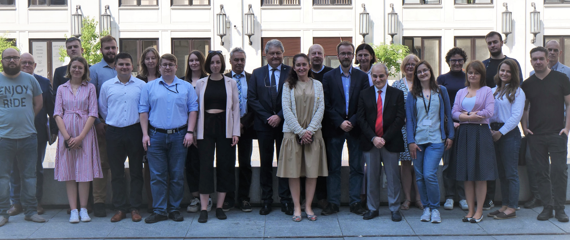Uczestnicy szkolenia na temat kultury bezpieczeństwa stoją w dwóch rzędach. Uśmiechają się 