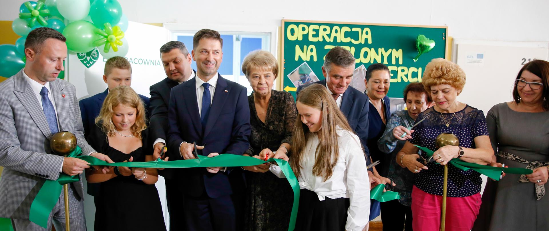 Uczniowie i nauczyciele przecinają wstęgę.