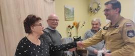 Przekazanie czujek seniorów z rak funkcjonariusza PSP
