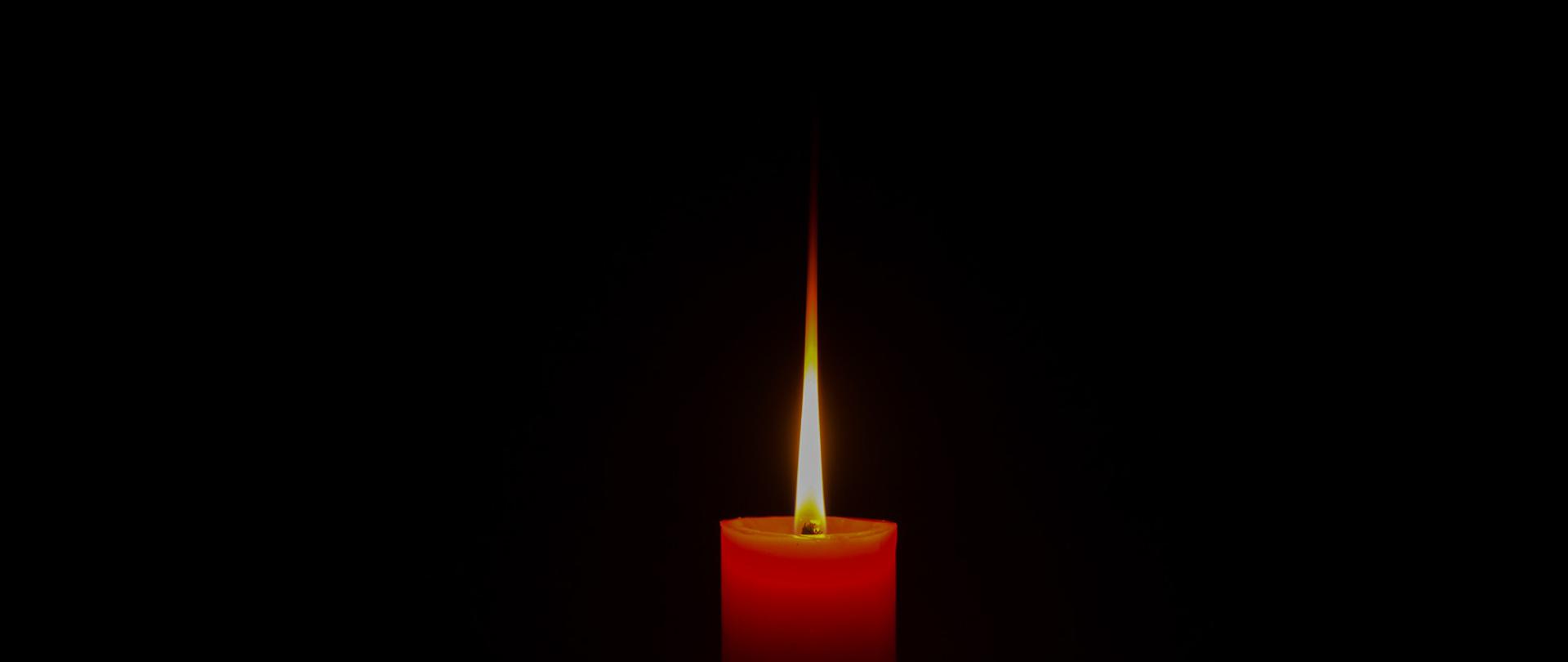 One candle light reflecting the shadow Black background