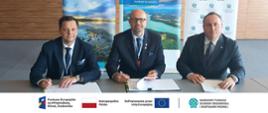 Podpisanie umowy. Zdjęcie grupowe. W stopce grafiki ciąg logotypów: Fundusze Europejskie na Infrastrukturę, Klimat, Środowisko, flaga Rzeczypospolita Polska, flaga UE i Dofinansowane przez UE, NFOŚiGW.