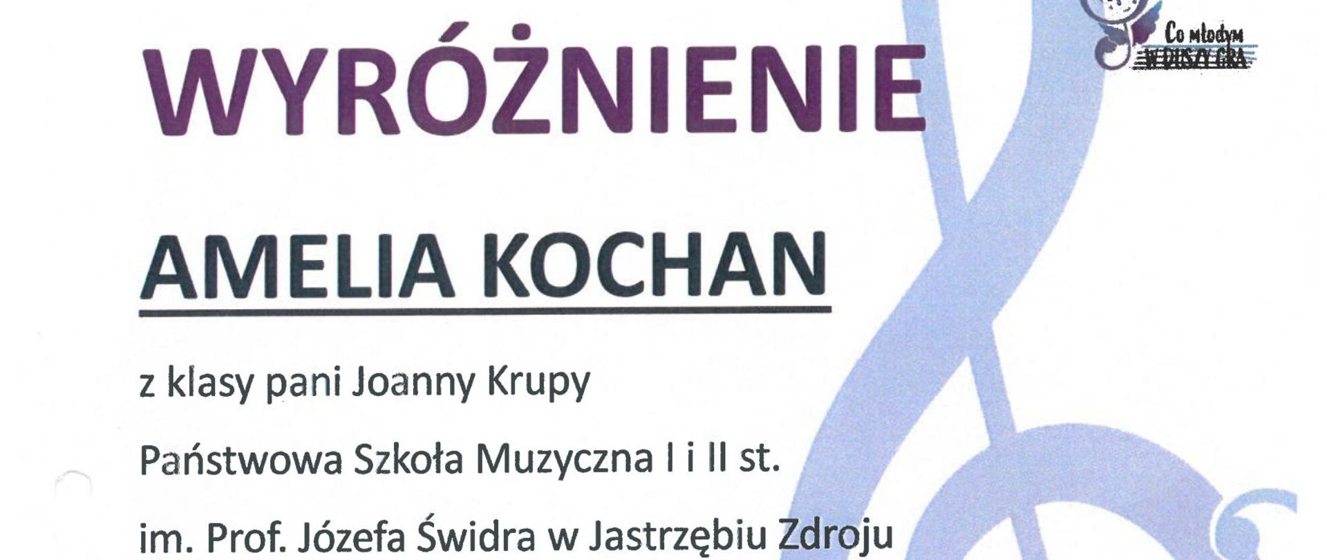 Białe tło, po prawej u góry logo konkursu, poniżej po prawej duży klucz wiolinowy. Po lewej: wyróżnienie Amelia Kochan z klasy pani Joanny Krupy Państwowa Szkoła Muzyczna I i II st. im. prof. Józefa Świdra w Jastrzębiu-Zdroju w III Ogólnopolskim Konkursie "Co młodym w duszy gra?", 13-15 kwietnia 2023 r. Zespół Szkół Muzycznych I i II st. w Rudzie Śląskiej. Poniżej skład jury i podpisy. Na samym dole logo Patronat, opieka merytoryczna oraz sponsorów.