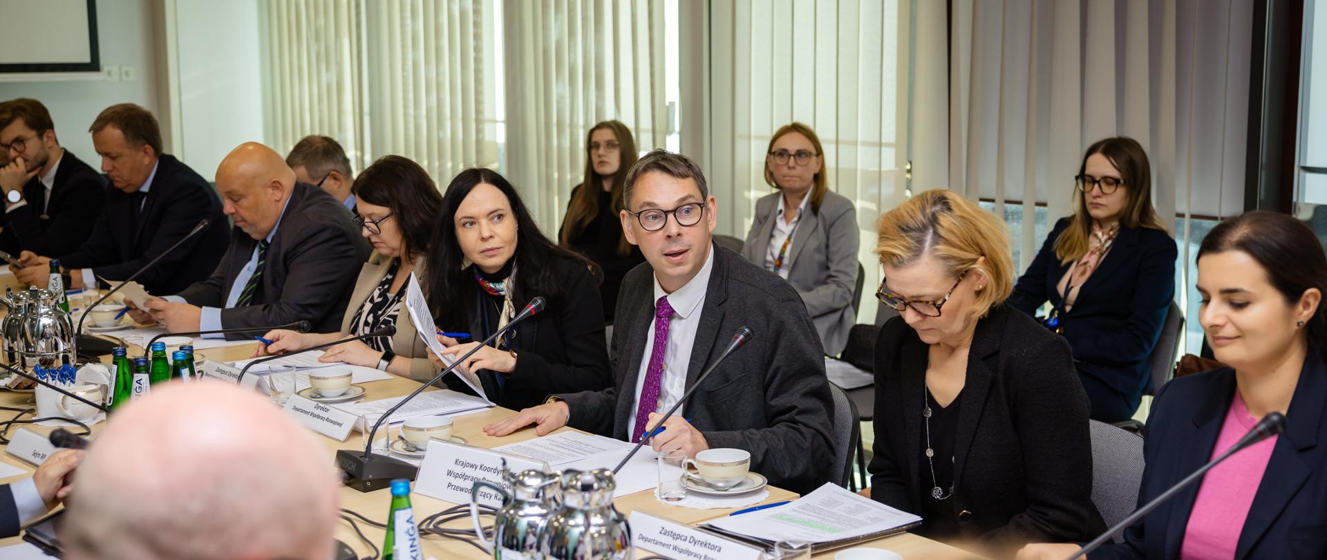 Kobiety i mężczyźni siedzą przy długim stole