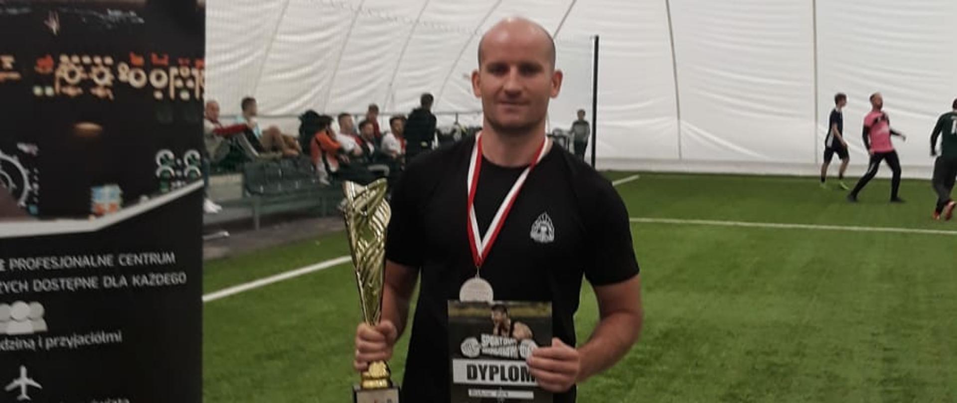 st. ogn. Piotr Puławski z dyplomem, medalem i pucharem za zajęcie drugiego miejsca w klasyfikacji mężczyzn