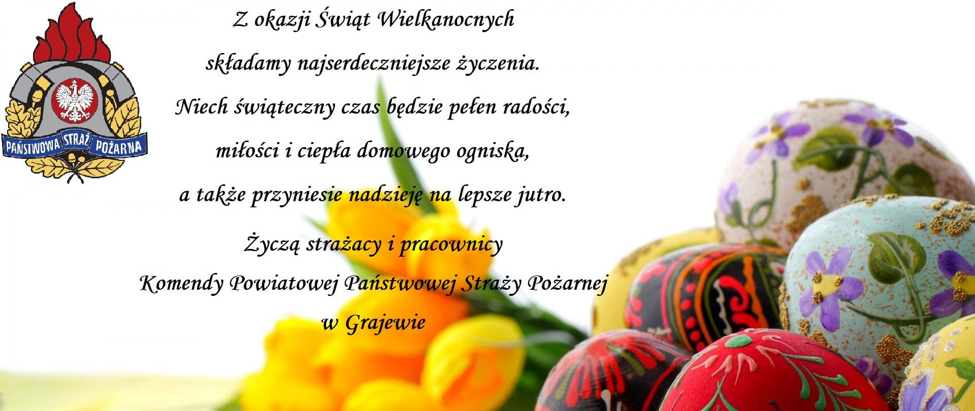 Koszyk z pisankami oraz bukiet tulipanów na białym tle.