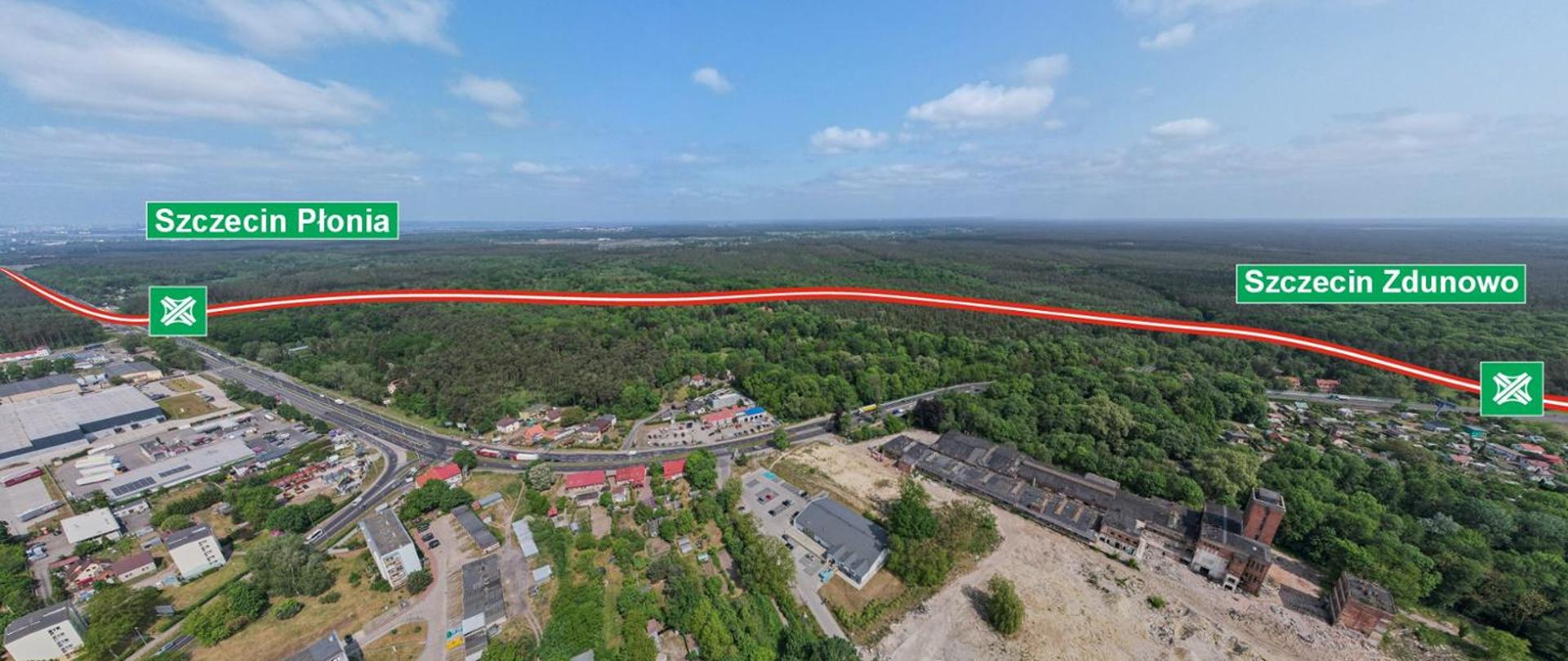 Panorama z lotu ptaka przedstawiająca fragment trasy S10 w okolicach Szczecina. Na zdjęciu widoczny jest las przecinany czerwoną linią symbolizującą przebieg drogi, z oznaczeniami dwóch węzłów: „Szczecin Płonia” po lewej stronie i „Szczecin Zdunowo” po prawej. W dolnej części kadru znajdują się zabudowania przemysłowe, magazyny oraz fragmenty dróg lokalnych, a w tle rozciąga się rozległy obszar leśny.