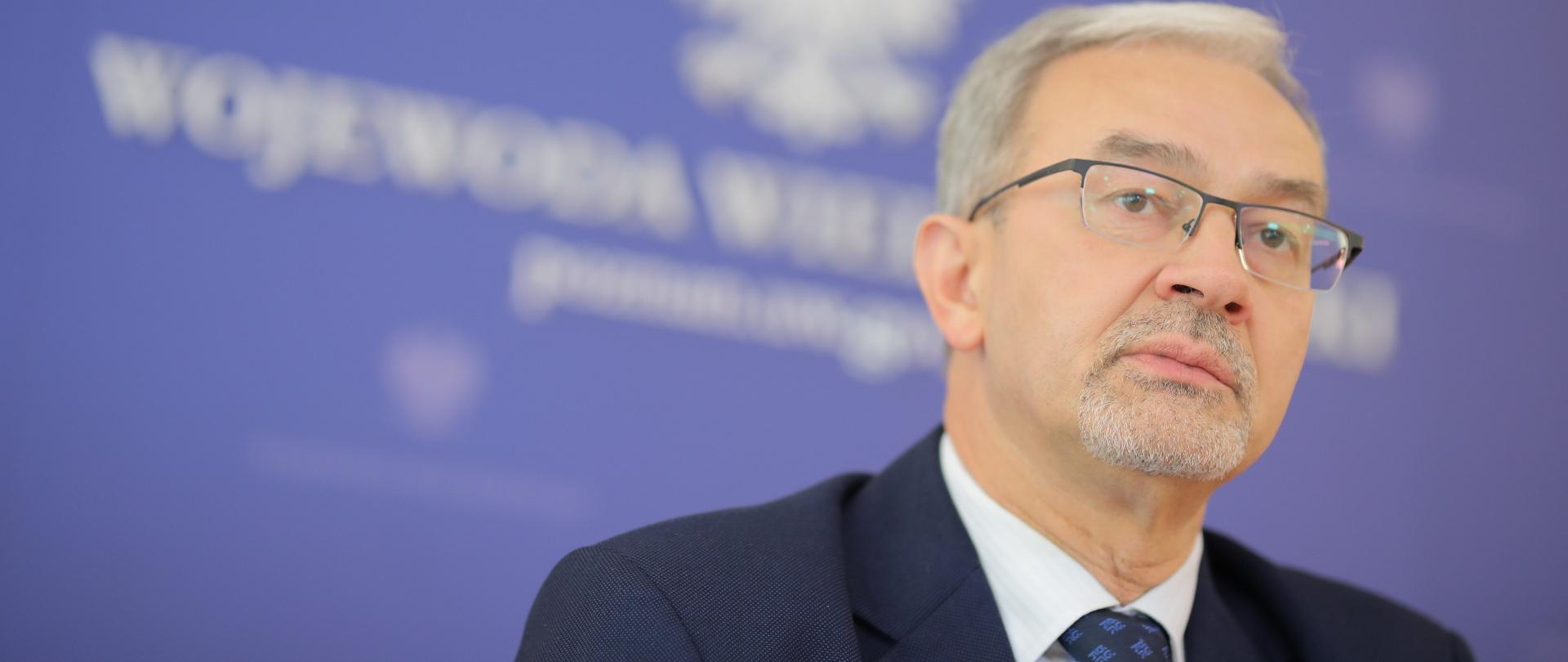 Minister Jerzy Kwieciński za nim na niebieskim tel napis wojewoda wielkopolski