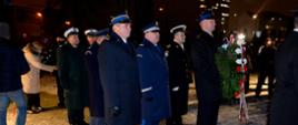 Funkcjonariusze służb mundurowych składają wieniec pod pomnikiem.