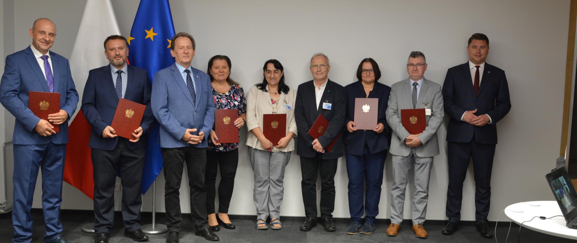 Minister Bernacki w towarzystwie kobiet i mężczyzn, którzy otrzymali powołania na członków zespołu doradczego ds. programu pod nazwą „Perły nauki” 