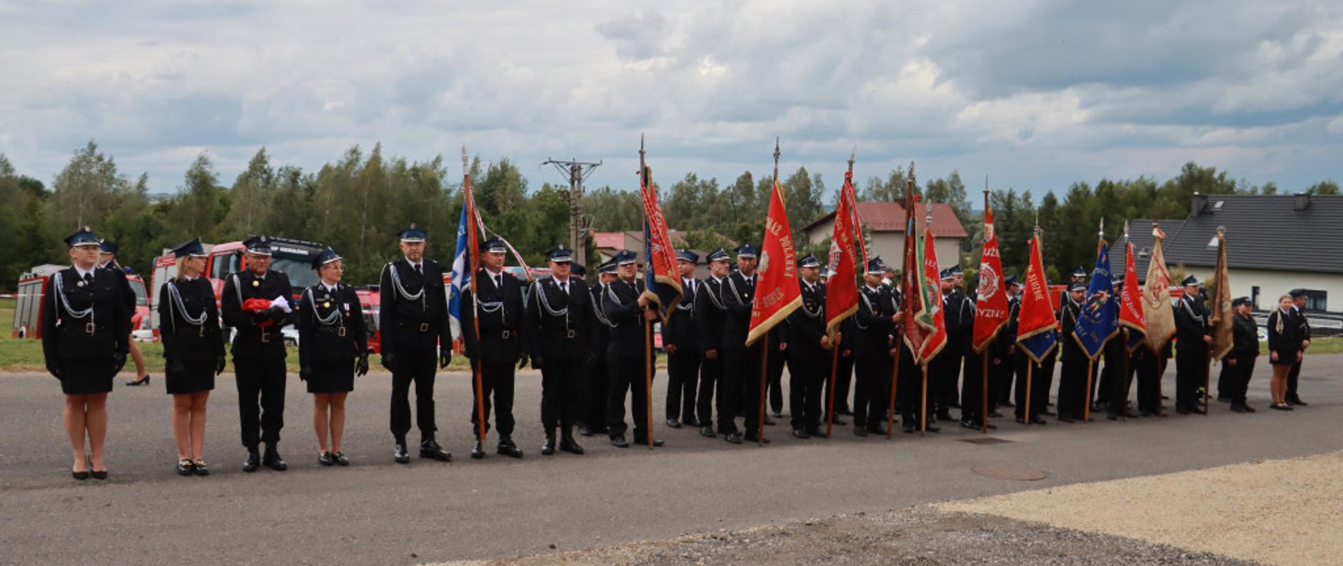 Zdjęcie przedstawia poczty sztandarowe jednostek OSP podczas obchodów 80-lecia OSP Rzeniszów 