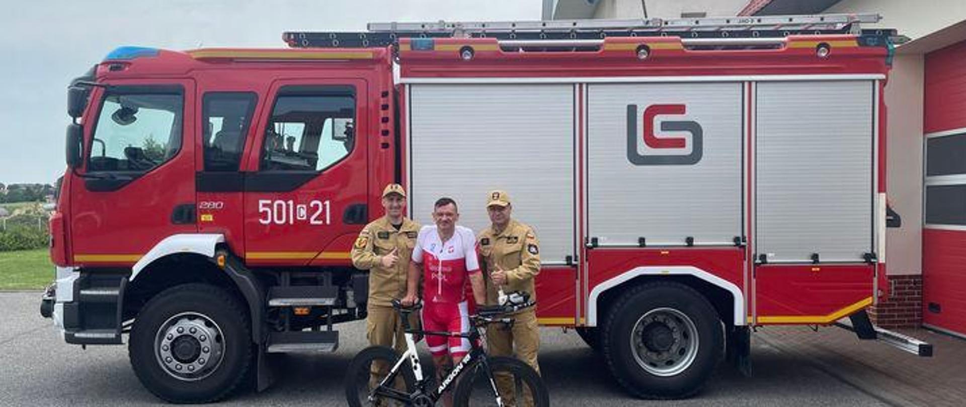 Zdjęcie przedstawia trzech funkcjonariuszy PSP z Radziejowa na tle samochodu pożarniczego.