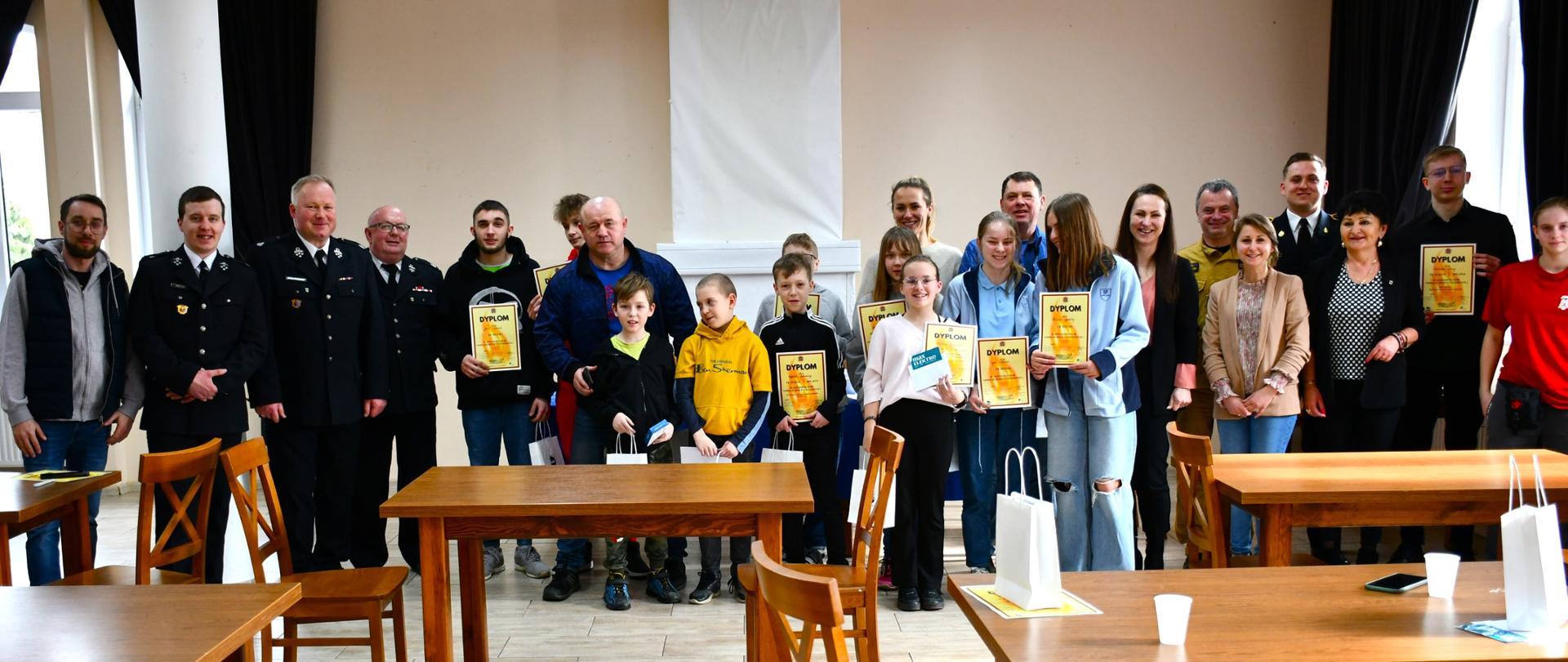 Zdjęcie grupowe przedstawiające uczestników wraz z rodzicami i opiekunami oraz komisją turnieju.