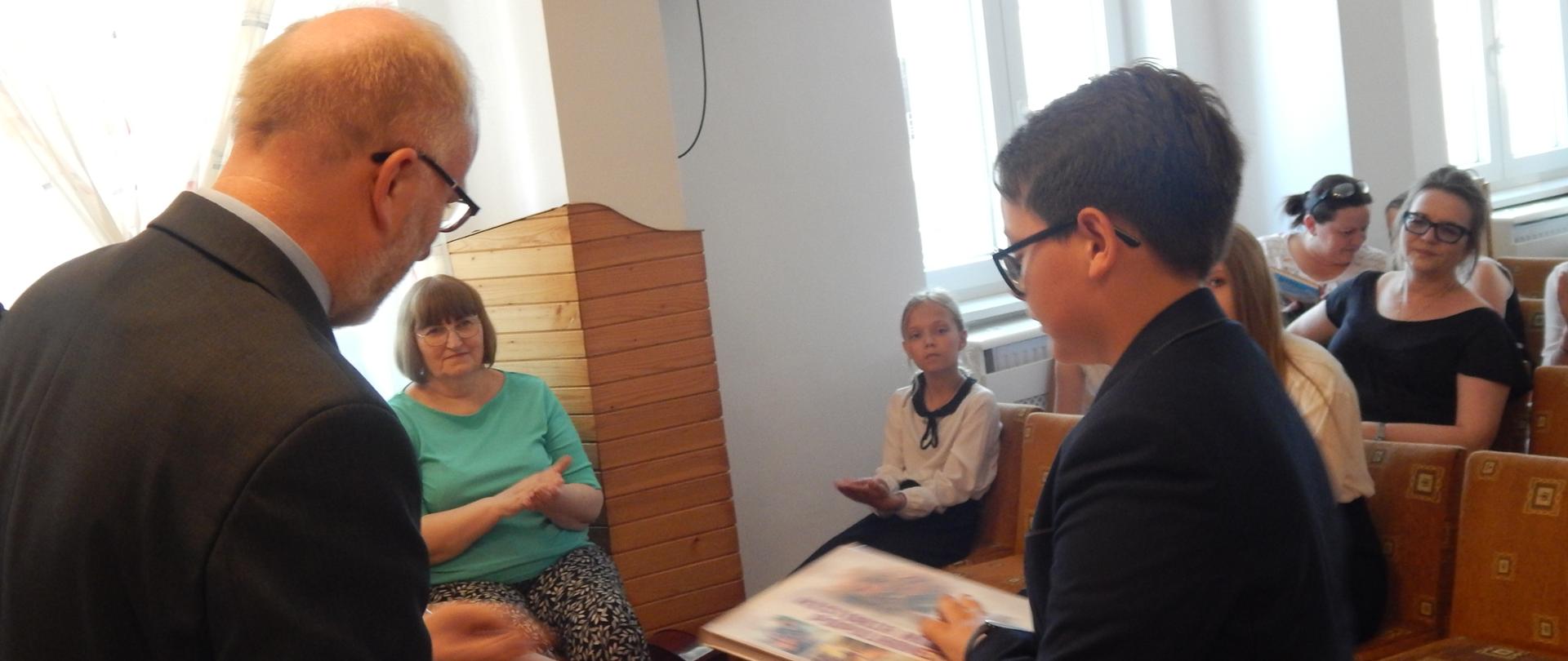 Dyrektor wręcza nagrodę uczniowi