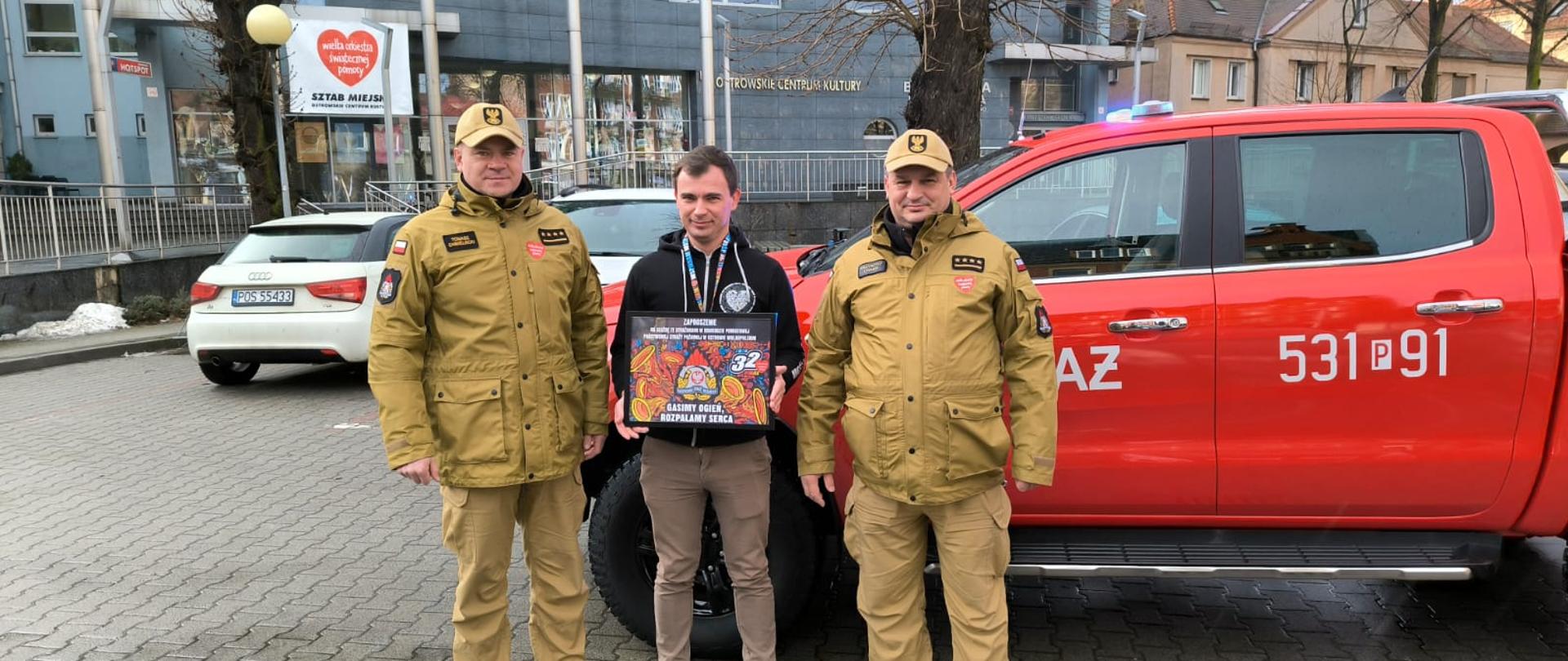 Strażacy przekazujący voucher