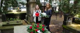 Na środku zdjęcia widać 2 uczennice składające kwiaty na grobie Stanisława Moniuszki