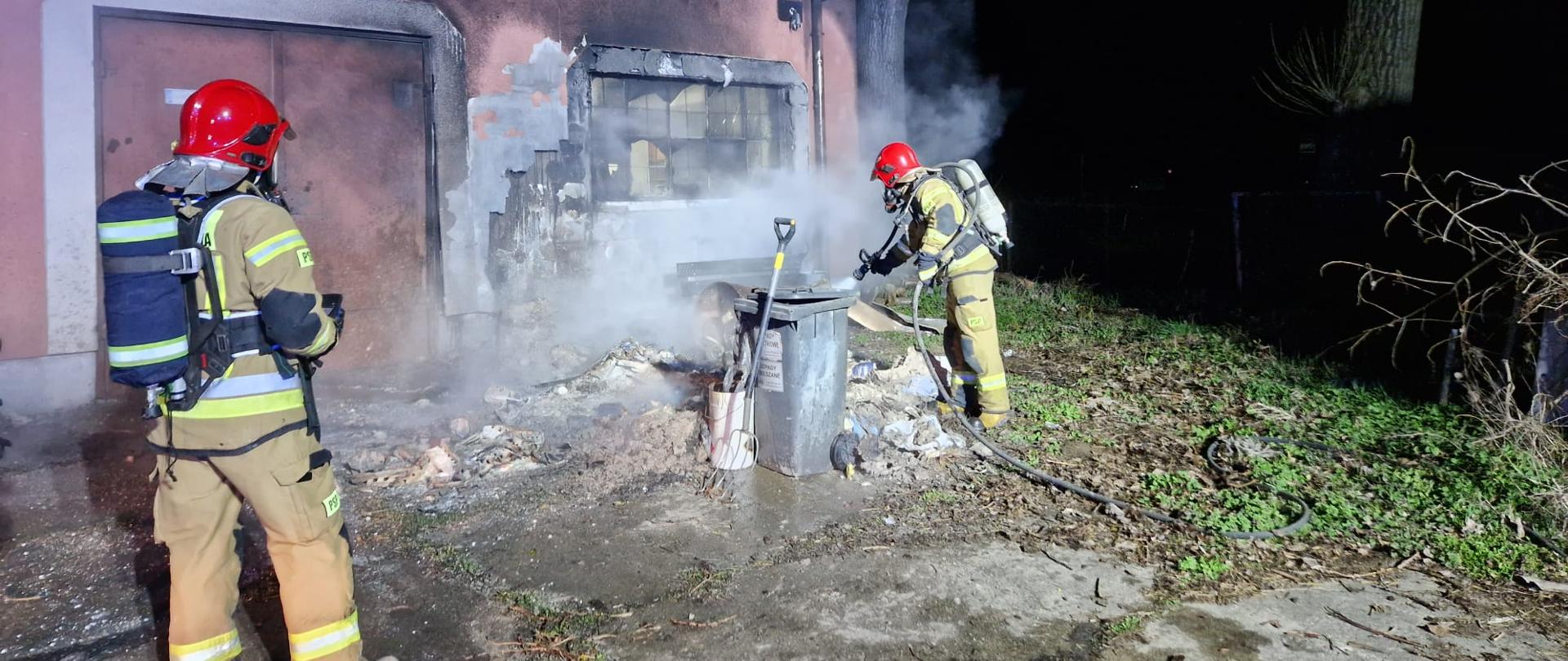 Strażacy przy palącym się śmietniku