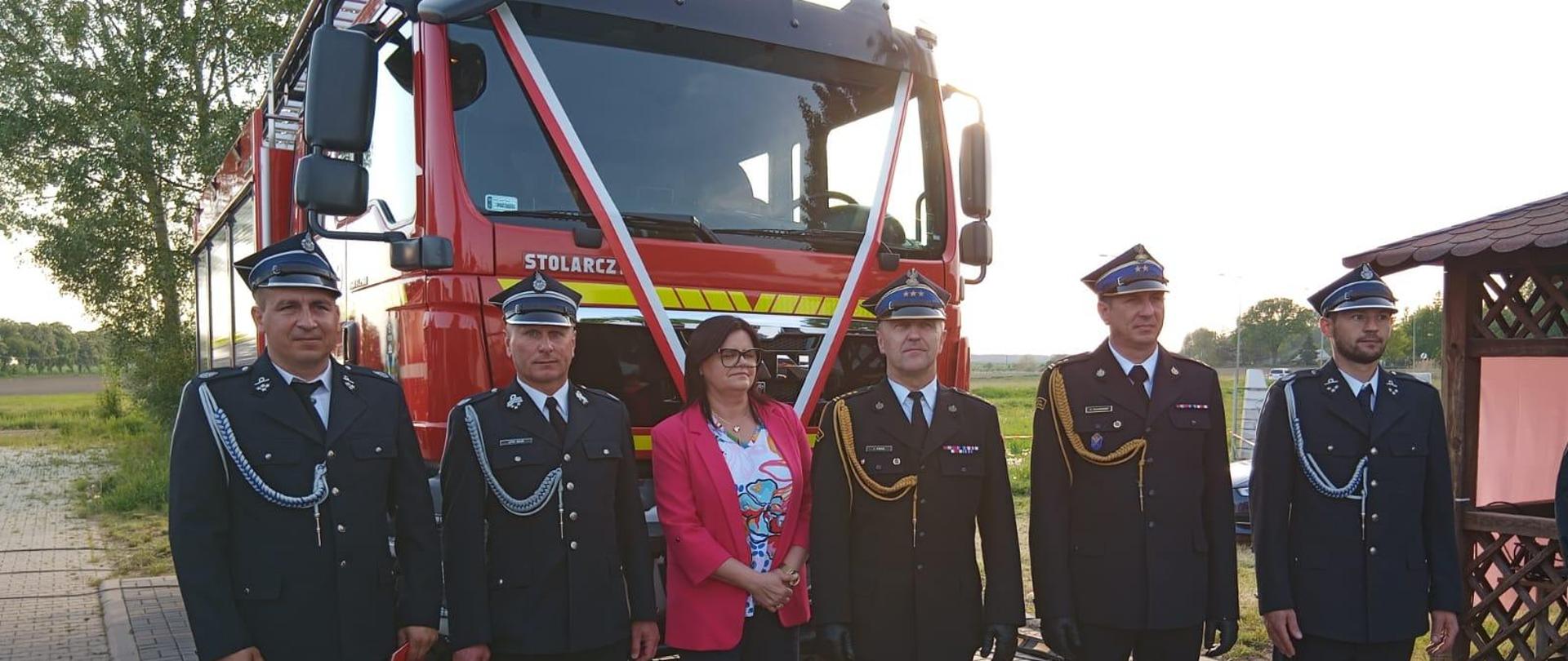 Zaproszeni goście i strażacy przy samochodzie