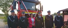 Zaproszeni goście i strażacy przy samochodzie