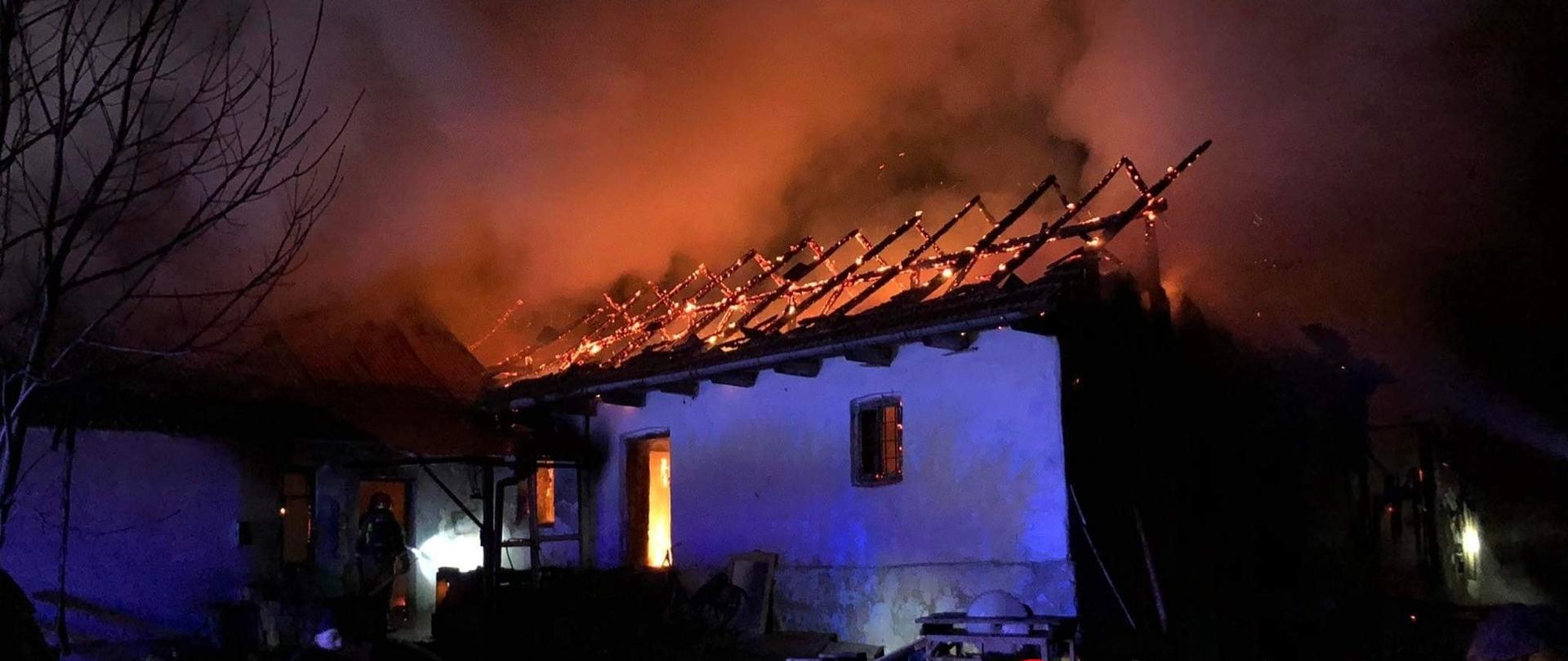 Na miejscu widoczny pożar domu jednorodzinnego i przyległego budynku inwentarskiego