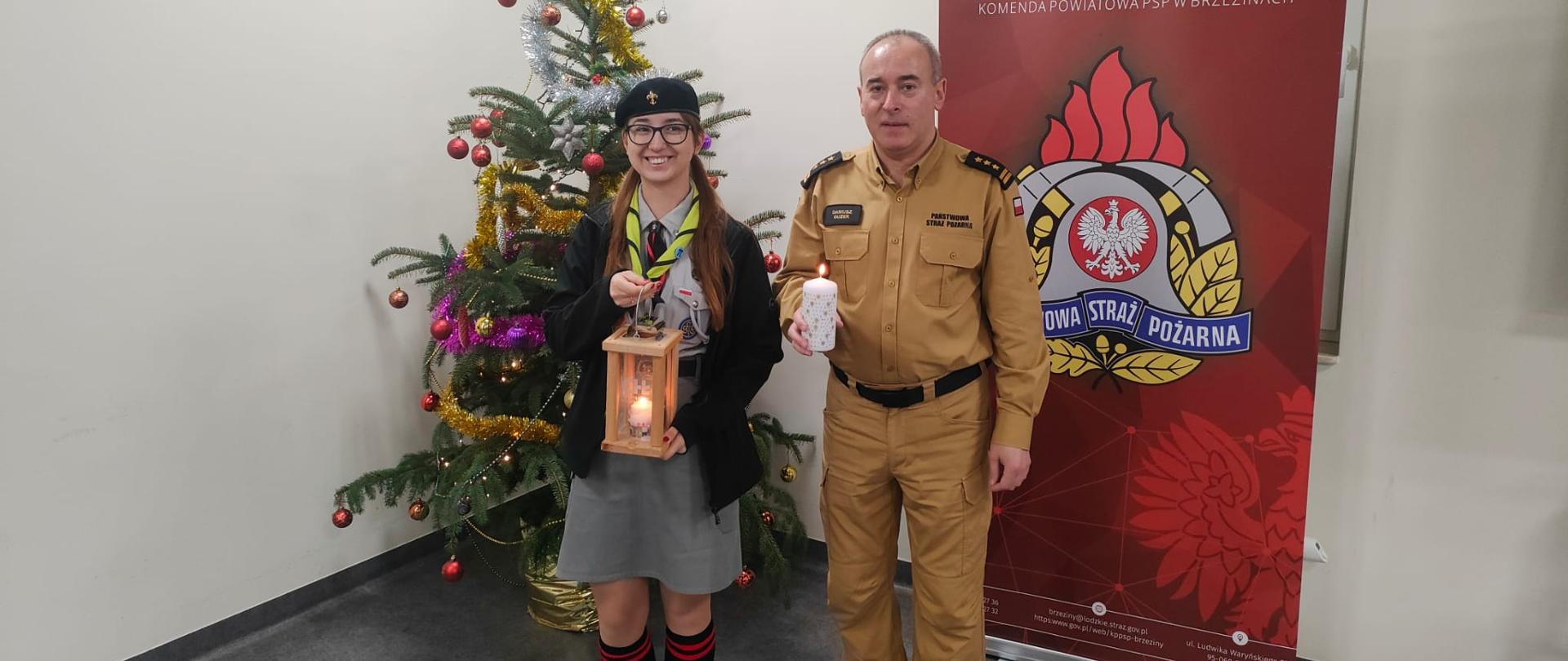 Sala konferencyjna komendy powiatowej państwowej straży pożarnej w brzezinach komendant powiatowy starszy brygadier dariusz guzek odebrał z rąk harcerki światło betlejemski ,