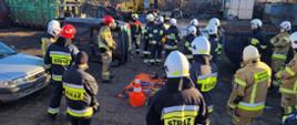 Zdjęcie przedstawia grupę strażaków, podczas zapoznania ze specjalistycznym sprzętem wykorzystywanym podczas wypadków drogowych przez Straż Pożarną.