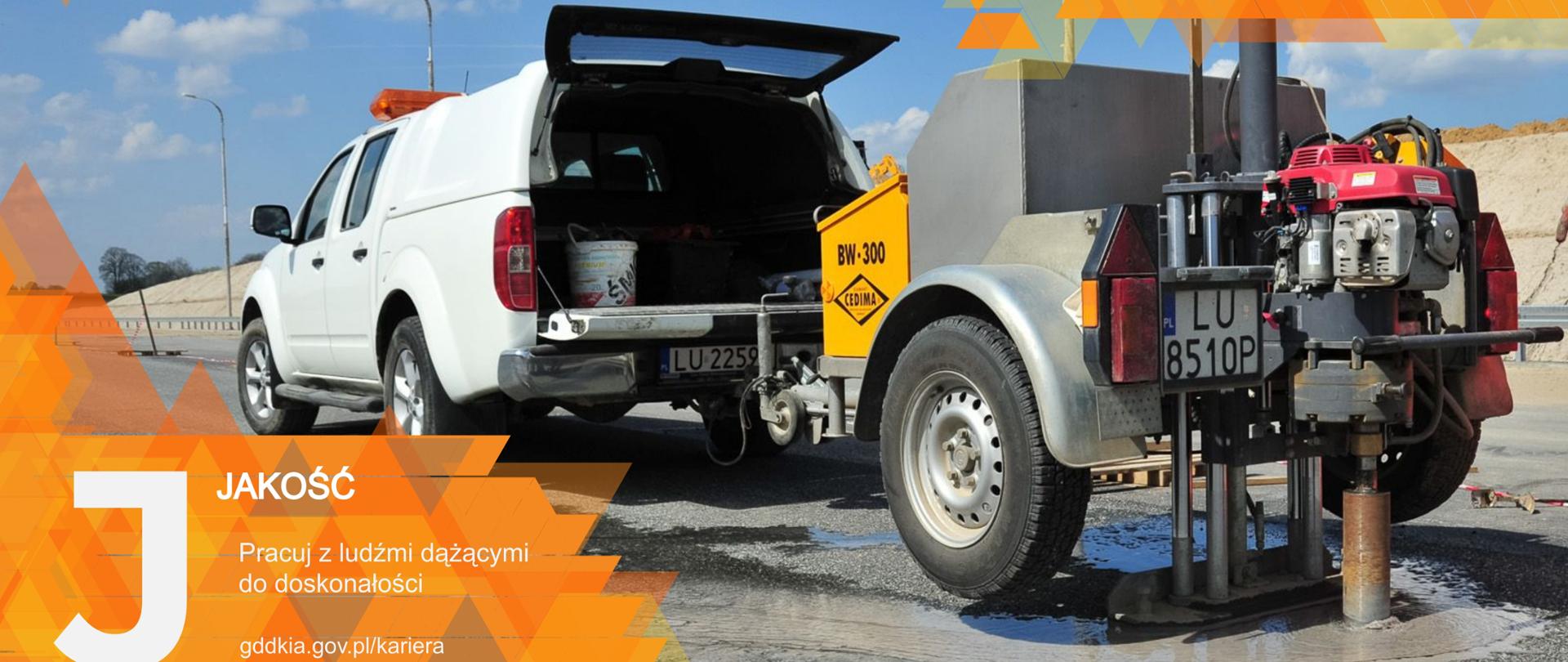 maszyna wiercąca otwór w nawierzchni drogi, stoi za samochodem