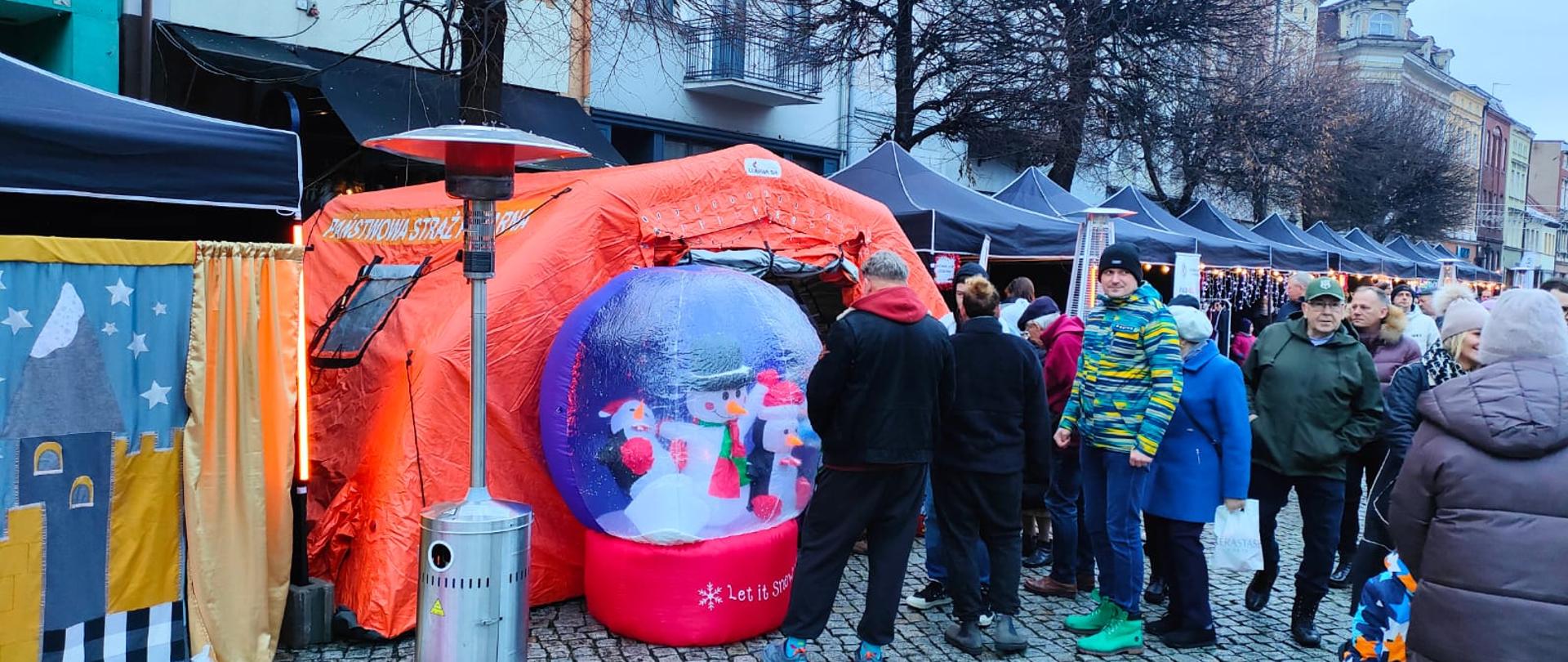 Dzieci i rodzice wchodzą do namiotu strażąckiego.