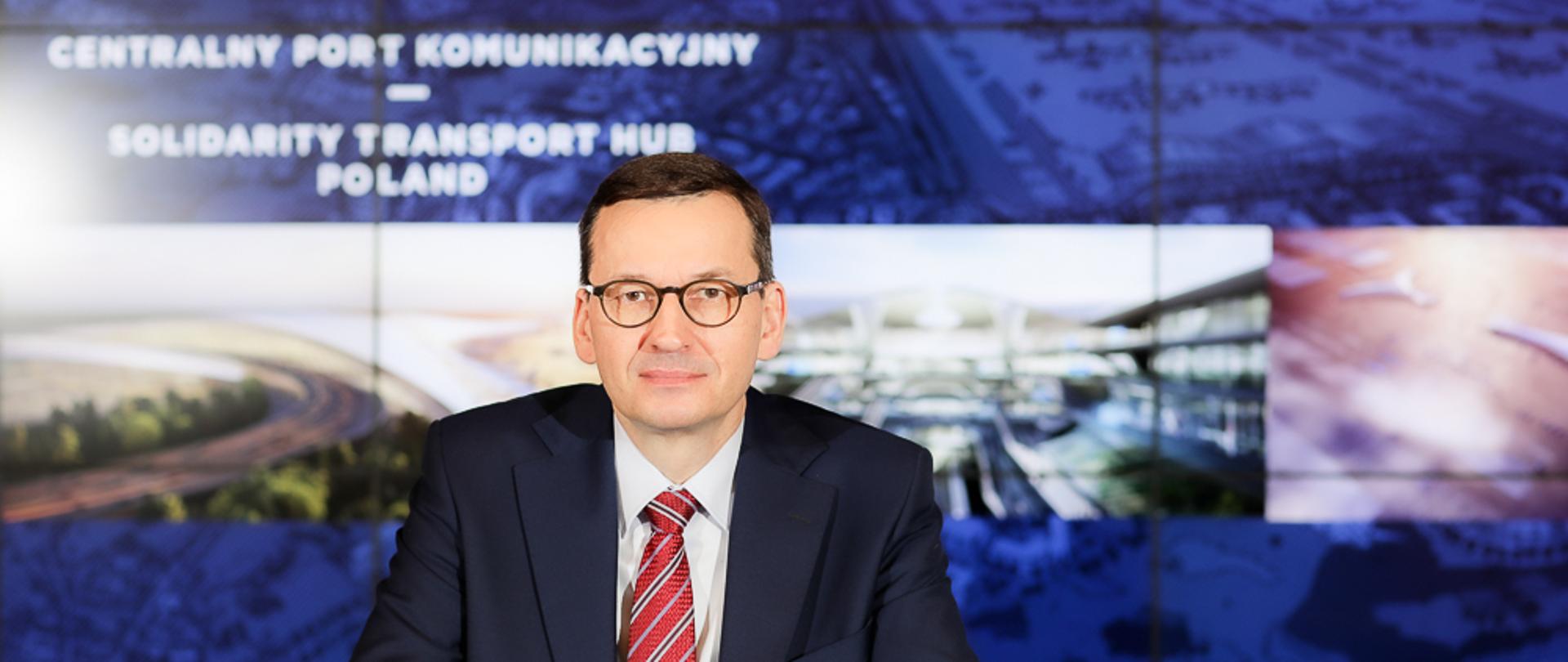 Premier Mateusz Morawiecki na tle napisu Centralny Port Komunikacyjny.
