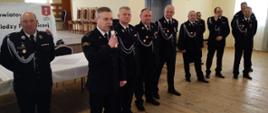 Zdjęcie przedstawia dziesięciu strażaków w mundurach wyjściowych podczas podsumowania turnieju wiedzy pożarniczej