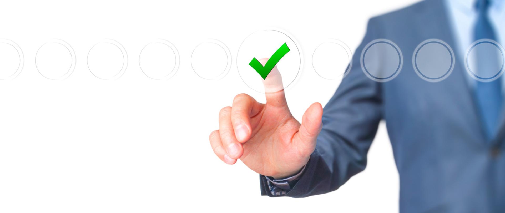 Męska dłoń naciskająca przezroczysty przycisk.