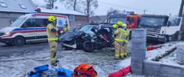 Na zdjęciu widać strażaków oraz rozbite pojazdy, a w tle wozy ratownicze 