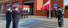 Strażacy podczas wciągania flagi na maszt