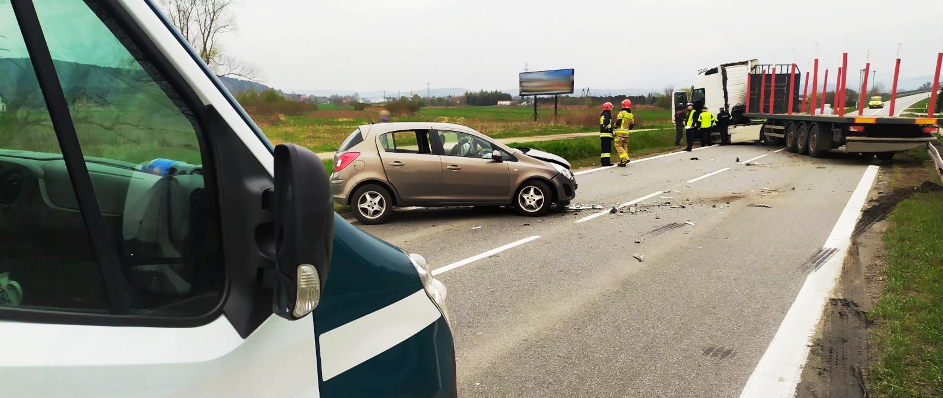 Inspektorzy małopolskiej Inspekcji Transportu Drogowego na miejscu wypadku, do którego doszło na drodze wojewódzkiej nr 969. Na pierwszym planie, po lewej inspekcyjny furgon. W centrum uszkodzony samochód osobowy. W oddali, po prawej pojazd ciężarowy.